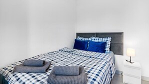 A bedroom with a bed, pillows, a bedside table, and a lamp. - Holiday Apartment "Soleole1" with Shared Terrace & Wi-Fi (Gandia)