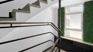 A staircase with a concrete finish, black metal railings, and a window with a green wall. - Holiday Apartment "Soleole8" with Shared Terrace, A/C & Wi-Fi (Gandia)