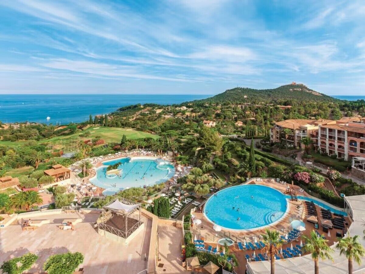 Un complexe hôtelier doté de plusieurs piscines, d’une végétation luxuriante et offrant une vue sur la mer.