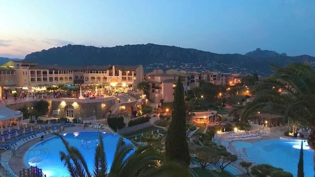Un complexe hôtelier doté de plusieurs piscines, d’un grand bâtiment avec des balcons et situé dans un cadre montagneux.