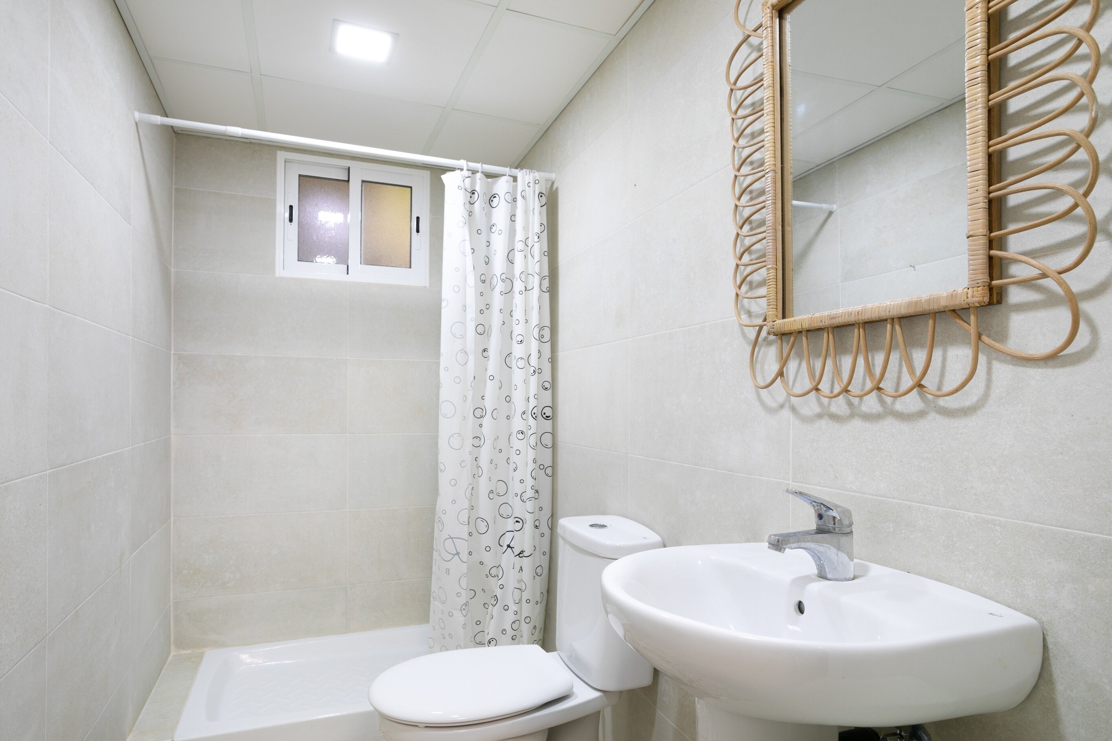 Une salle de bain avec des toilettes, un lavabo et un rideau de douche.