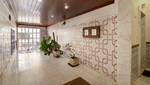 A hallway with patterned walls, wooden ceiling beams, and potted plants. - Apartment 'Âncora B' with Private Terrace (Monte Gordo)
