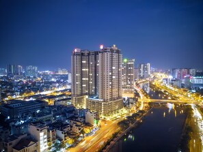 A nighttime cityscape with high-rise buildings, a river, and illuminated roads. - Luxury Millenium Apartment (Ho Chi Minh City)