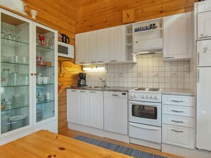 Eine Küche mit weißen Schränken, einem Siemens Geschirrspüler, einem Siemens Backofen und einer Mikrowelle.