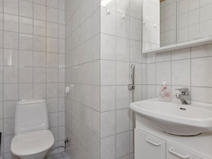 Une salle de bain avec des toilettes, un lavabo et un miroir.