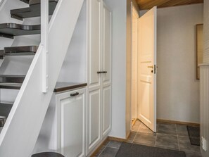 Un escalier avec une rampe, une porte blanche et un radiateur.