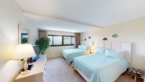 A room with two beds, a desk with a lamp, a window with curtains, and a plant. - Coastal Hideaway 2 Bedroom Condo with Ocean Views (Pawleys Island)