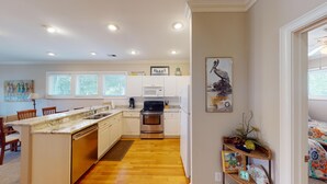 A modern kitchen with white cabinets, a stainless steel oven, and a granite countertop. - Golf and Beach: 2BR Lakeside Villa with Lake Views (Pawleys Island)