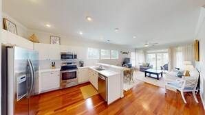 A modern kitchen with white cabinetry, stainless steel appliances, and a wooden floor. - Lake Views, 2BR, 2BA, Lakeside Villa (Pawleys Island)