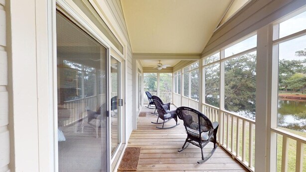 A covered porch with two rocking chairs and a ceiling fan. - Lake Views, 2BR, 2BA, Lakeside Villa (Pawleys Island)