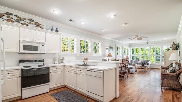 A spacious kitchen with white cabinetry, a built-in microwave, and a large island. - Beautiful 2BR 2BA Lakeside Villa with Lake Views (Pawleys Island)