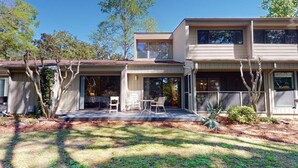 A modern two-story house with a covered patio and outdoor seating area. - Beach and Golf Dreams: 3 Bedroom 2 Bath (Pawleys Island)