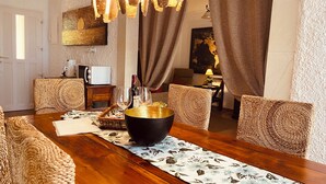 A dining area with a wooden table, woven chairs, and a central black bowl. - Sonne, Ruhe, Leuchtend Turkisblaues Wasser und Feinster Sandstrand (Cala Mendia)