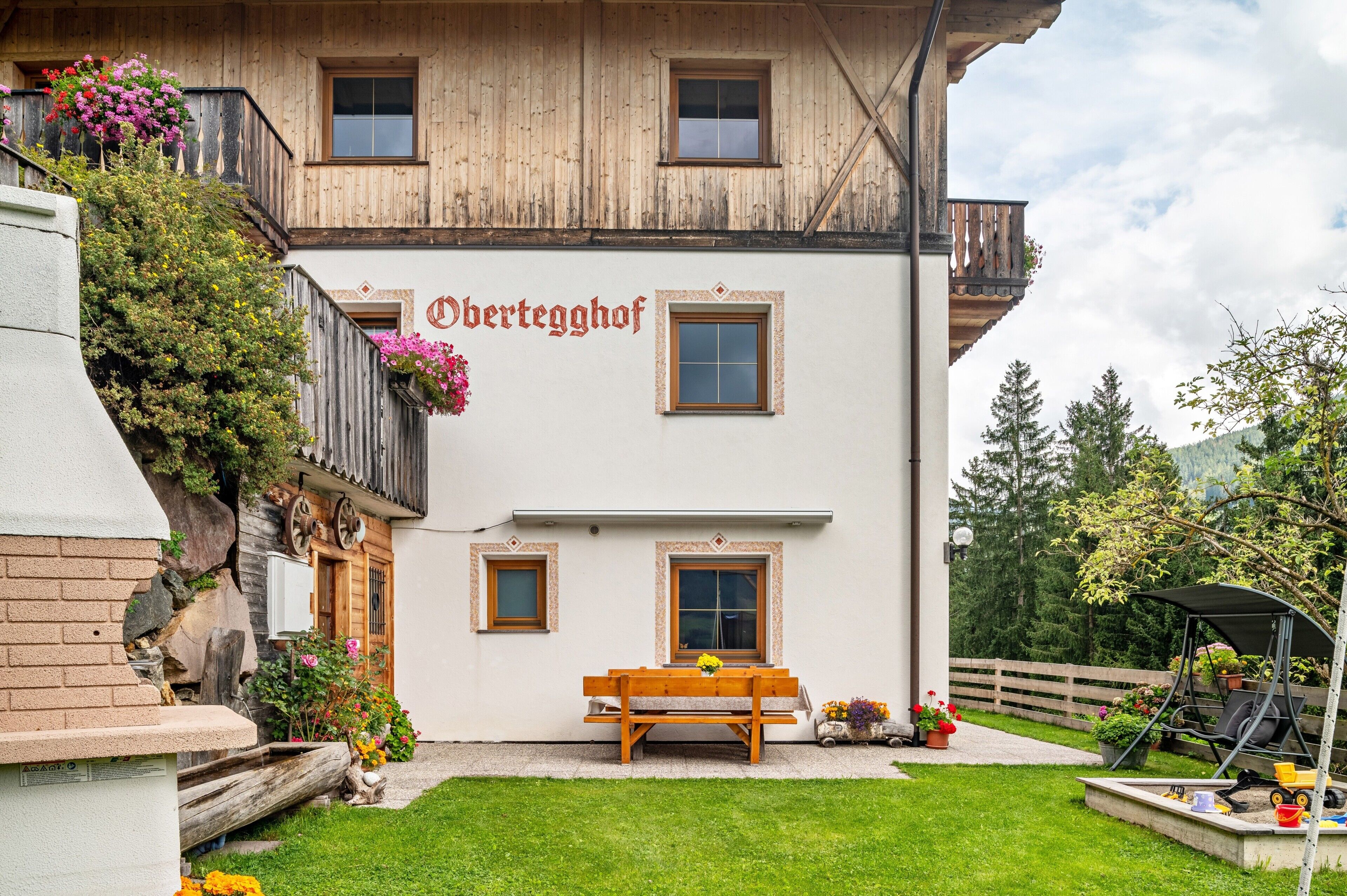 Ein traditionelles Holzhaus mit einem Schild, auf dem 'Obertegghof' steht.