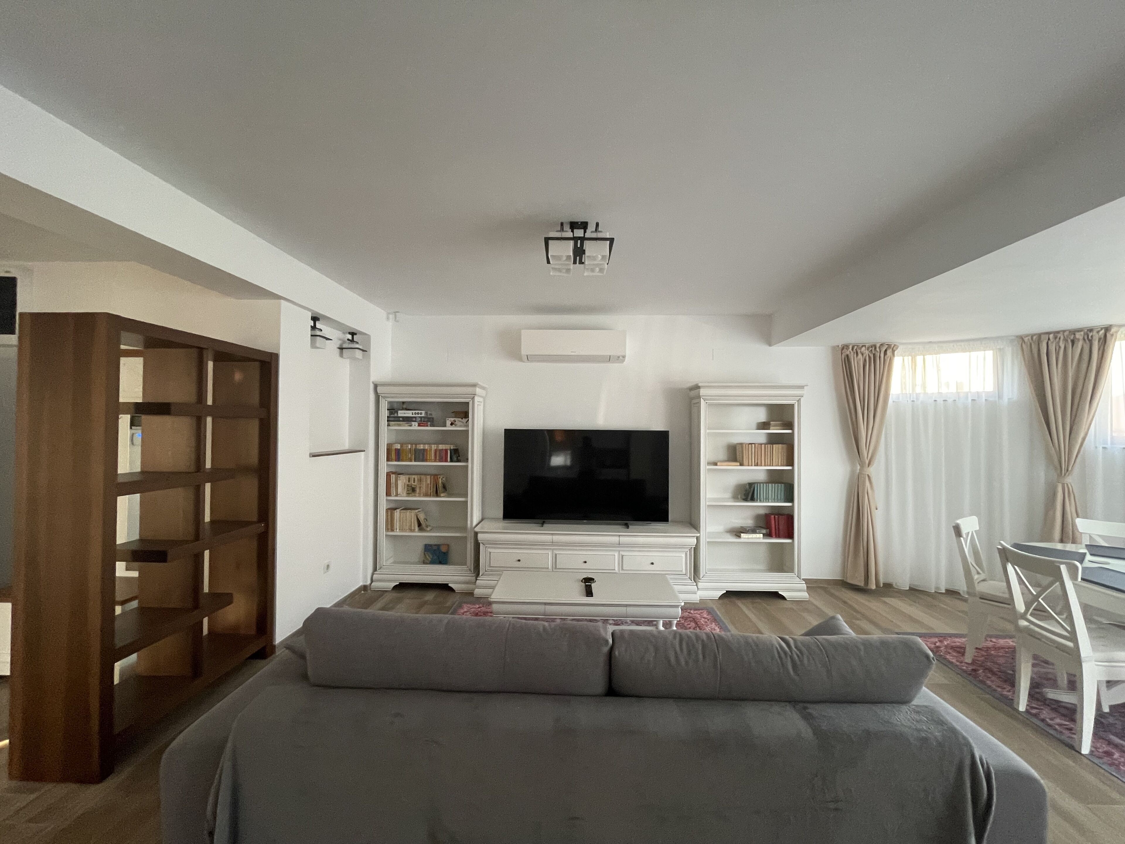 Una sala moderna con sofá, televisor de pantalla plana y estanterías empotradas.