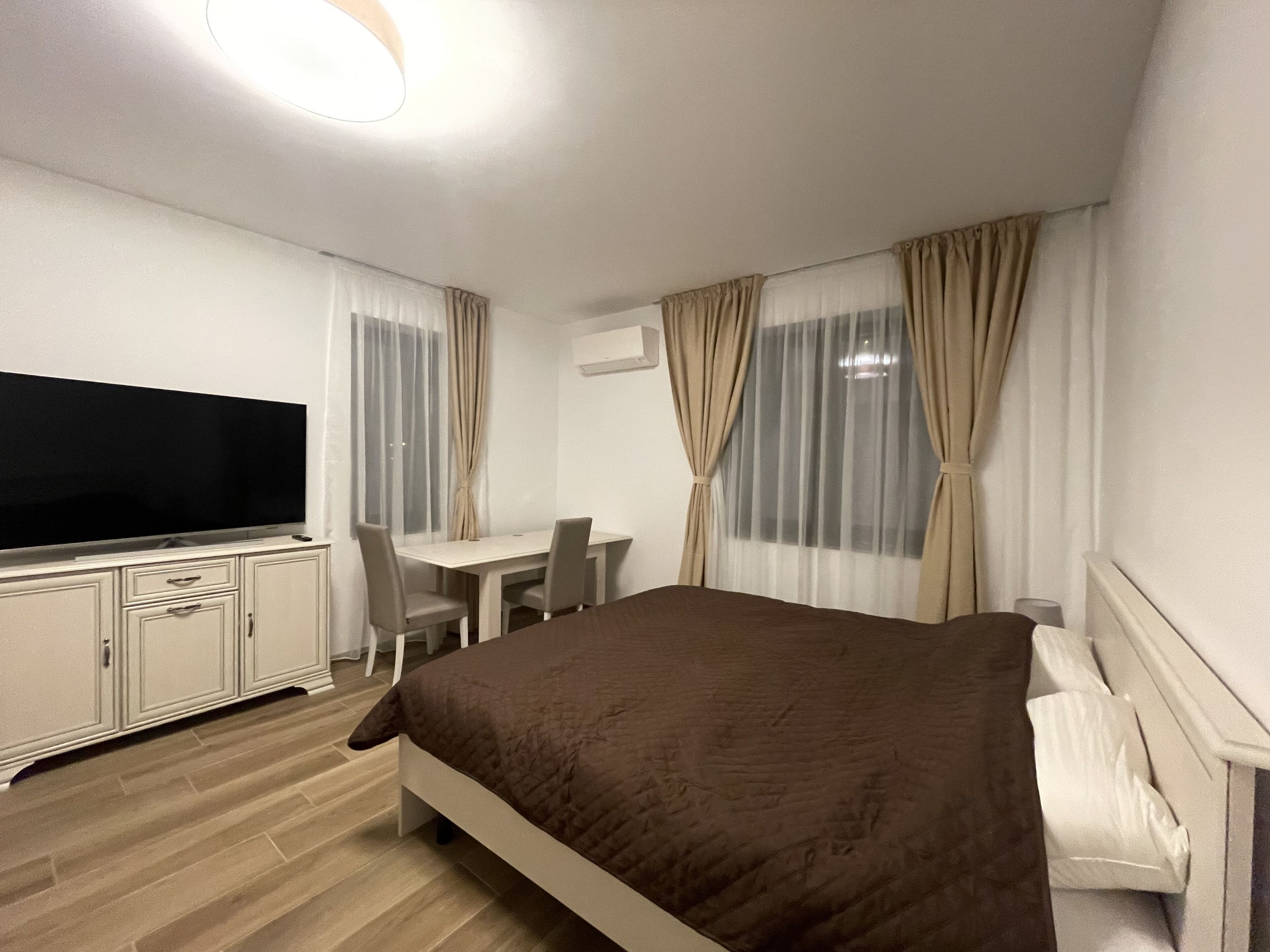 Ein Hotelzimmer mit Bett, Fernseher, Schreibtisch und Stuhl.