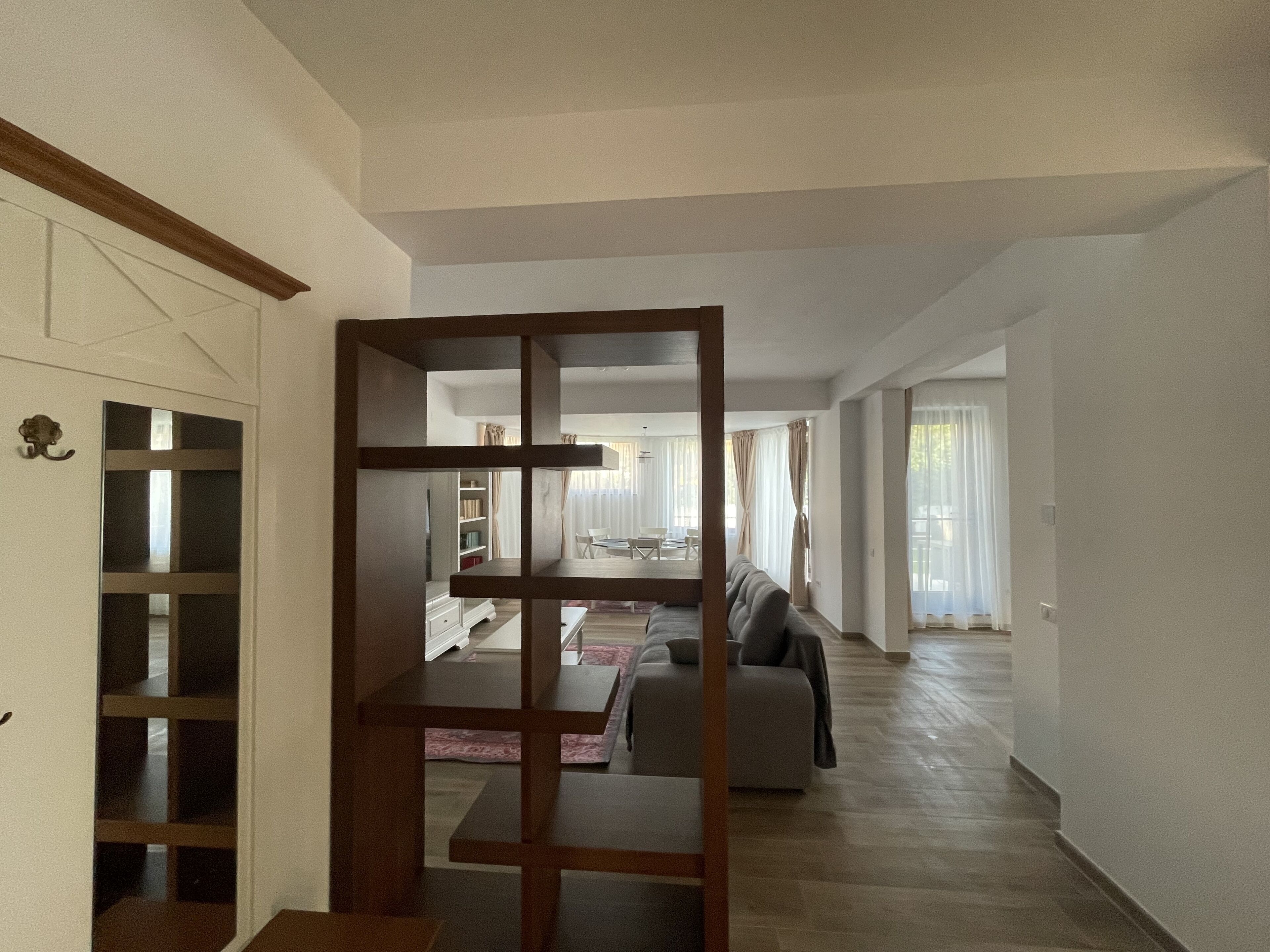 Een ruime woonkamer met een houten scheidingswand, een bank en een eettafel.