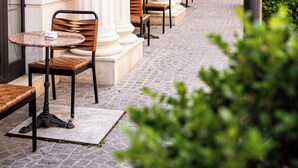 A hotel corridor with columns, outdoor seating, and a sign for 'Env Hotel'. - Envy Hotel (Durrës)