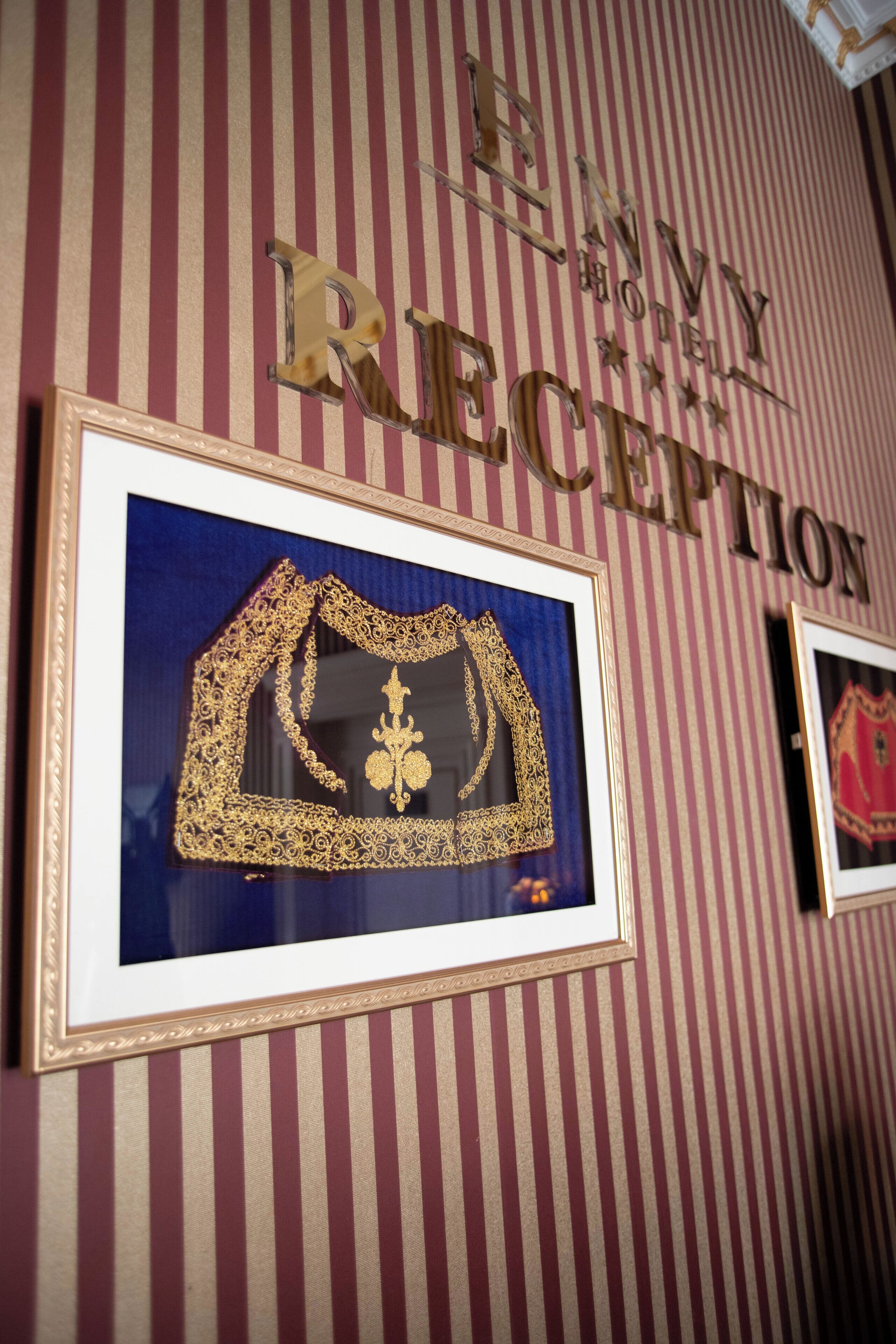 A reception area with a striped wall and framed artwork.