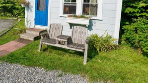 A small white house with a blue door, a window with a flower box, and a wooden bench outside. - Isleview Cottage 4 - 10 minutes to Acadia! (Trenton)