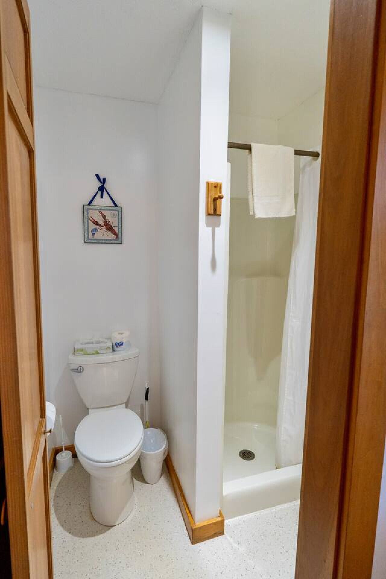 A compact bathroom with a toilet, bidet, and shower stall.
