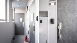 A hallway with a fire extinguisher, a door with a number plate, and a wall-mounted intercom. - JR Nippori 5min | 4F New Private Room | Kitchen, Wi-Fi, Washer | Promo Rate R403 (Arakawa City)