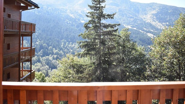 A wooden cabin with a balcony overlooking a mountainous landscape. - Cozy studio near slopes - 4 guests (Méribel)