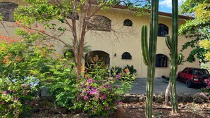 A building with arched windows and a cactus garden. - Seaside Serenity; 2b/2b with Panoramic Terrace (Playas Del Coco)