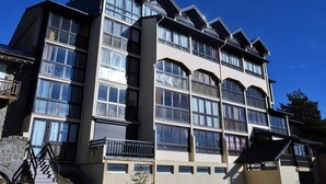 A multi-story building with large windows and balconies. - Charming 2-room cabin in central Font-Romeu, parking included (Font-Romeu-Odeillo-Via)