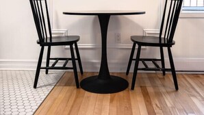A room with a round table and two chairs, a white wall, and a wooden floor. - #9 - Studio/Plateau/St-Denis/SelfCheck-In/AC/TV (Montréal)
