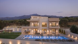 A modern two-story house with a swimming pool, outdoor seating, and a view of mountains. - Casa Beleza Villa, a Mythical Retreat (Perama)