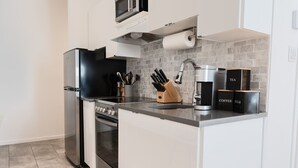 A modern kitchen with a built-in oven, a microwave, a coffee maker, and a knife block. - #10 - Studio/Plateau/St-Denis/SelfCheck-In/AC/TV (Montréal)