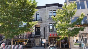 A multi-story building with a visible storefront, a bicycle parked outside, and a staircase leading to an upper level. - #11 - Studio/Plateau/St-Denis/SelfCheck-In/AC/TV (Montréal)