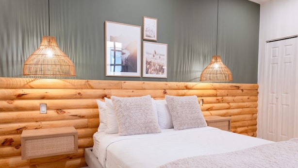 A log cabin-style bedroom with a bed, two wall-mounted lamps, and framed pictures. - #2 - Studio/Plateau/St-Denis/SelfCheck-In/AC/TV (Montréal)