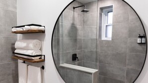 A circular mirror, a shower with a handheld showerhead, and a window with a view. - #2 - Studio/Plateau/St-Denis/SelfCheck-In/AC/TV (Montréal)