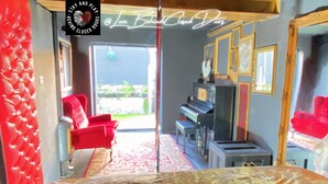 A room with a bed, a red chair, a piano, and a mirror. - Stay & Play at Lovebehindcloseddoors (Plymouth)