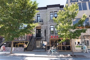 A multi-story building with a storefront, a bicycle parked outside, and a staircase leading to an upper level.