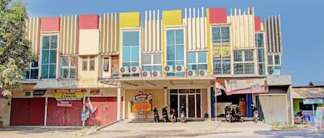 A multi-story building with a ground-level shop and several motorcycles parked in front.