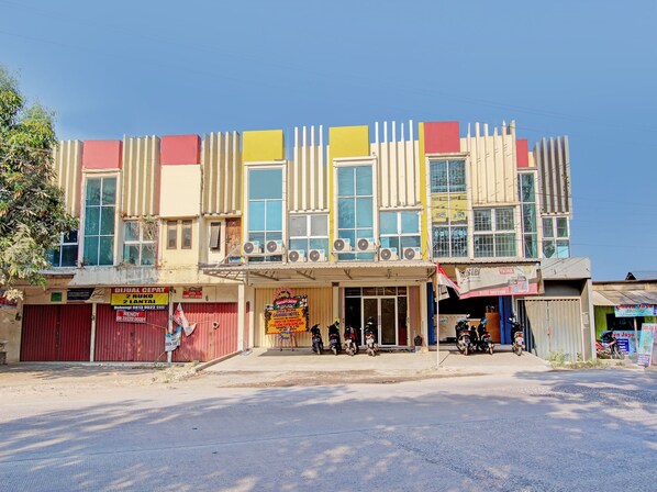 A multi-story building with a ground-level shop and several motorcycles parked in front.