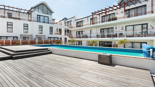 A modern hotel with a rooftop pool, multiple balconies, and a wooden deck. - Azure 32 (Cape Town)