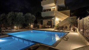 A modern two-story building with a swimming pool, outdoor seating, and a stone facade. - Villa Hibiscus with private pool & bbq (Spilia)
