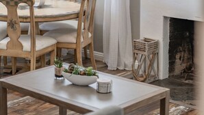Un comedor con una mesa redonda, sillas y un ventilador de techo.