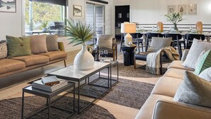 A spacious living room with a sofa, coffee table, and dining area. - Luxury at Lake Taneycomo, Hot Tub, FirePit, Views! (Hollister)