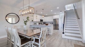 A modern kitchen with white cabinets, stainless steel appliances, and a central island. - Casa Al Mare 101 – Beachfront Luxury w/ Saltwater Pool, Private Trail, Balconies & Sunset Views (Indian Rocks Beach)