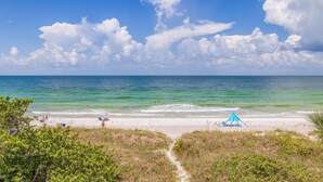 A beach with clear skies, calm waters, and a few people enjoying the sun. - Casa Al Mare 101 – Beachfront Luxury w/ Saltwater Pool, Private Trail, Balconies & Sunset Views (Indian Rocks Beach)