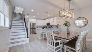 A modern kitchen with white cabinetry, stainless steel appliances, and a central island.