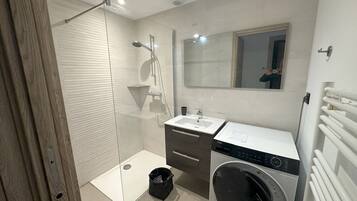 Een douche, een haardroger, handdoeken, toiletpapier