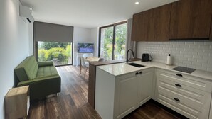 Une cuisine moderne avec des meubles blancs, un plan de travail en bois et un îlot central intégré.