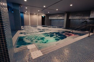 Una piscina techada, una piscina al aire libre de temporada, sombrillas