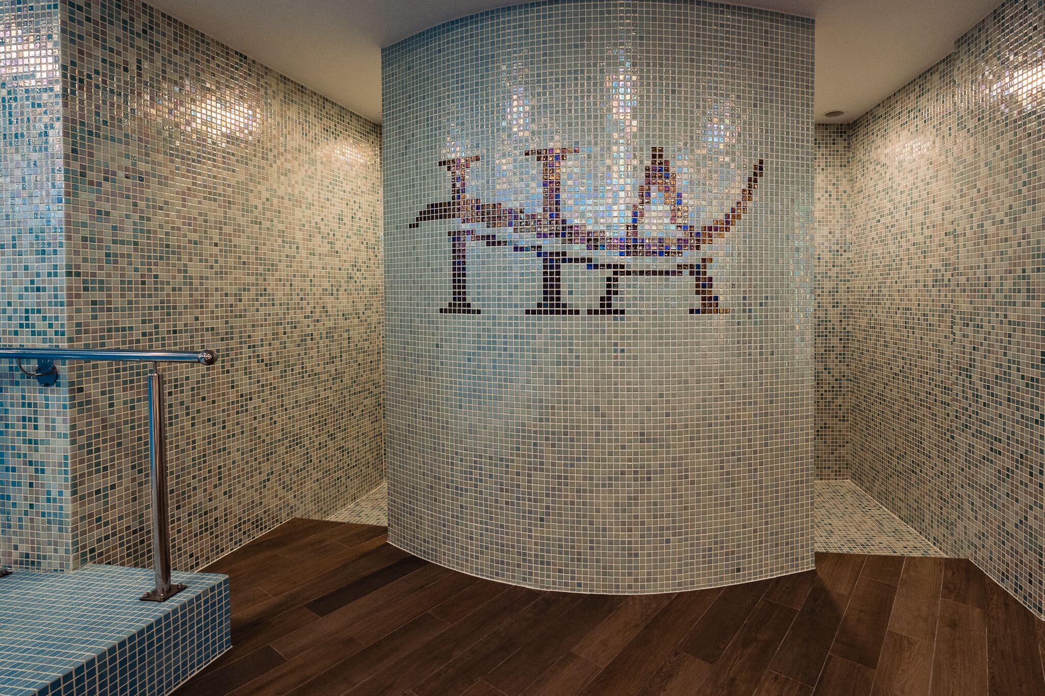 A circular room with mosaic tile walls and a wooden floor.